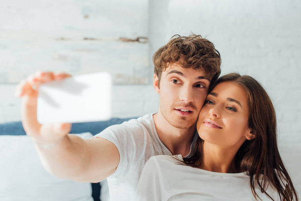 Selektywne skupienie się pary robiącej selfie w domu - Zdjęcie, obraz