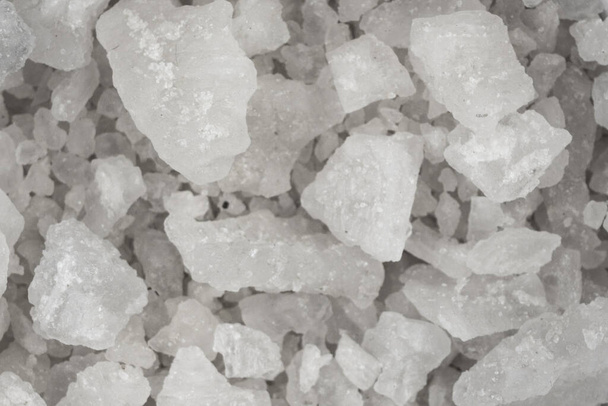 Spilled white sea salt texture background. Clear crystalline shaker pebbles macro, close up - Fotoğraf, Görsel