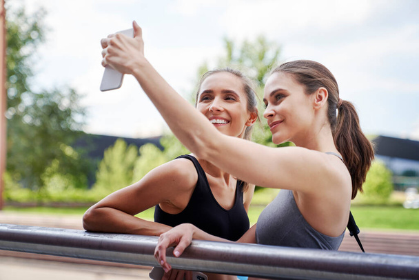 Zwei athletische Frauen machen ein Selfie                               - Foto, Bild