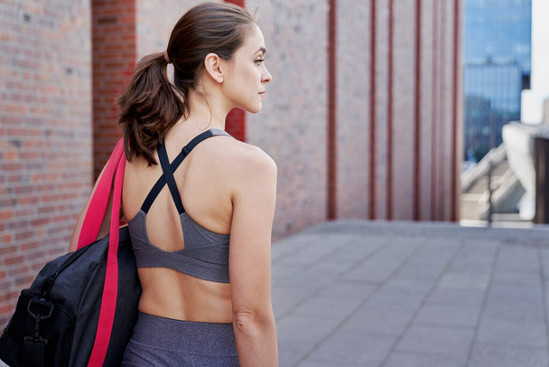 トレーニング服に身を包んだアスレチック女性の後ろ姿                                - 写真・画像