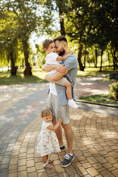 Happy young father with children relaxing  in the park - 写真・画像