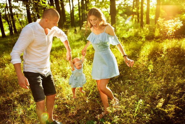 Happy young family with baby girl  in the park - Фото, изображение
