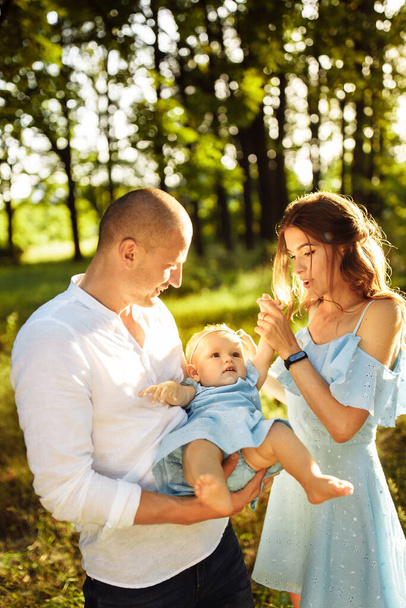 Happy young family with baby girl  in the park - 写真・画像