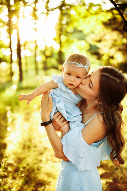 Happy young mother  with baby in the park - Фото, изображение