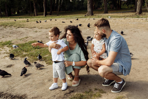 Happy young family with children relaxing  in the park by pond - Fotoğraf, Görsel