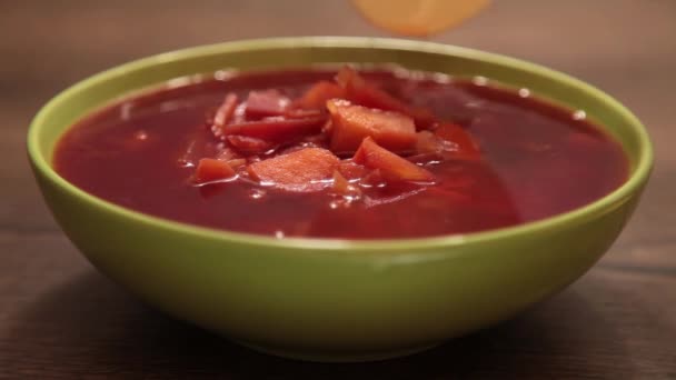delicioso borscht rojo en un plato verde - Metraje, vídeo