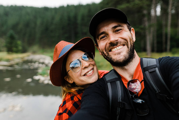 Selfie of a young couple in the mountains by the river - Foto, afbeelding