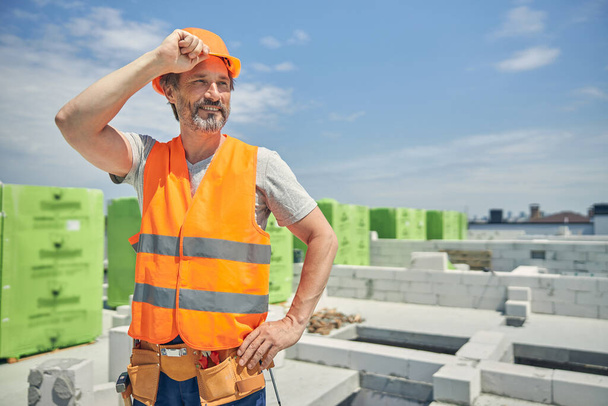 Male worker in a protective helmet standing outside - Photo, Image