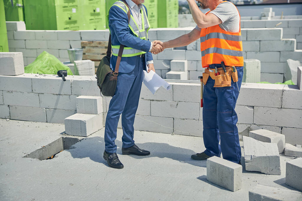 Homens cumprimentando uns aos outros no local de construção - Foto, Imagem