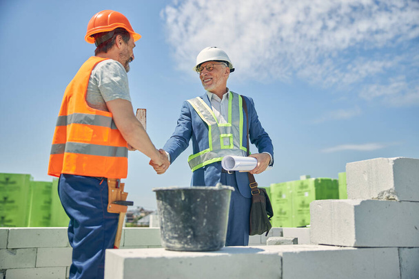 Potěšený stavební manažer potřásá rukou stavitele - Fotografie, Obrázek