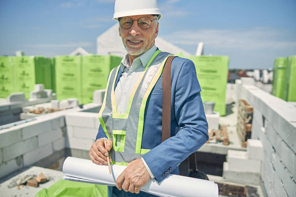 Мужчина-конструктор, стоящий на строительной площадке - Фото, изображение