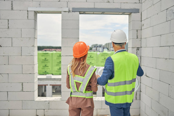 Female contractor and a civil engineer inspecting a construction object - Photo, Image