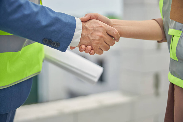 Woman in a safety waistcoat shaking her colleague hand - Foto, Imagem