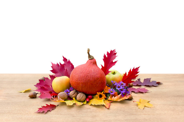 Kürbis japanisch, Äpfel, rote und gelbe Herbstblätter, Beeren, Walnüsse, Eicheln und Blumen auf Holztisch auf weißem Hintergrund. - Foto, Bild