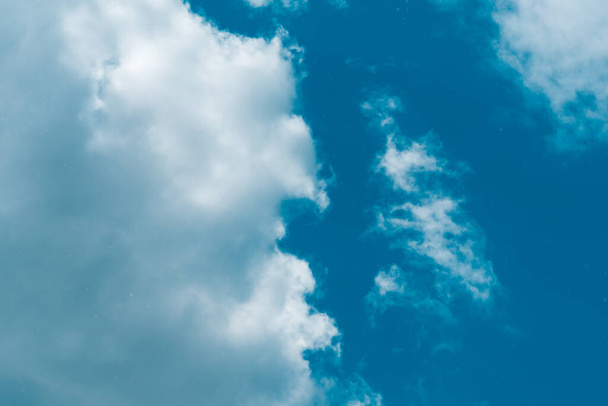 Lucht en pluizige wolken in de blauwe lucht op een zonnige dag, achtergrond textuur - Foto, afbeelding