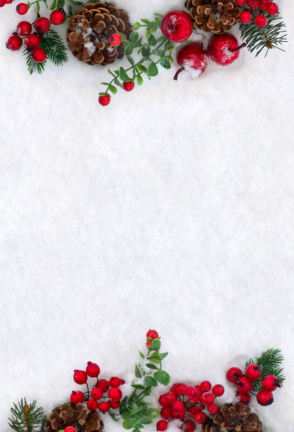 Świąteczne dekoracje. Ramka gałązki choinki, brązowe naturalne szyszki sosnowe i czerwone jagody na śniegu z miejscem na tekst. Widok z góry, płaski - Zdjęcie, obraz