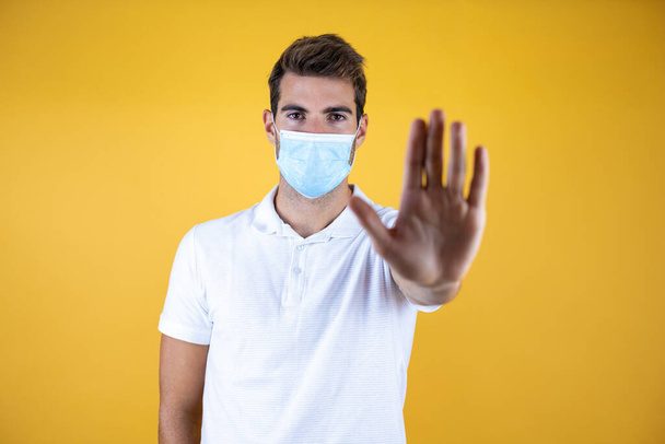 Handsome man wearing medical mask over isolated background . Healthcare concept. - Fotó, kép