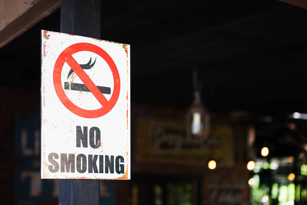 Κοντινό πλάνο ενός grunge rustry Δεν καπνίζοντες πινακίδα, εξωτερική μπροστά από ένα εστιατόριο φόντο, επιλεκτική εστίαση. - Φωτογραφία, εικόνα
