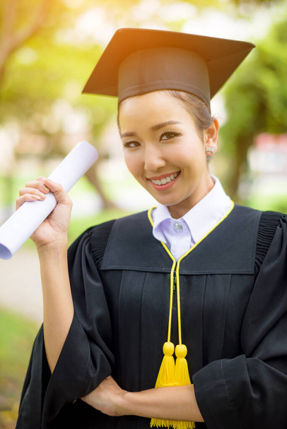 Graduated woman students wearing graduation hat and gown with happiness feeling with park background - Фото, зображення
