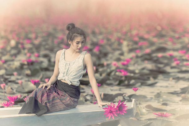 Asiatisches Mädchen im See der Lotusblumen, Frau trägt traditionelle, thailändische Menschen, Hübsches Mädchen mit dem Meer aus rotem Lotus, Udon Thani, Thailand, Unseen Thailand, Reisekonzept, Der Seerosensee im Sonnenaufgang - Foto, Bild