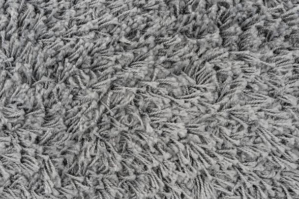 Fekete természetes gyapjú szőnyeg textúra háttér. Sötét gyapjú szövet textúra. töredékes szürke bozontos szőnyeg - Fotó, kép