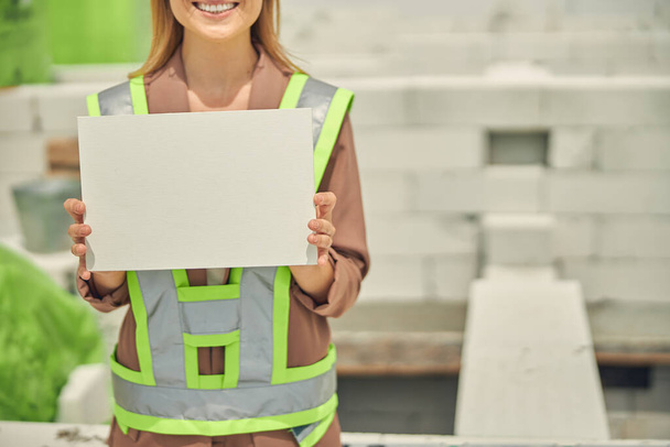 Sorrindo mulher construtora vestida em workwear de pé ao ar livre - Foto, Imagem