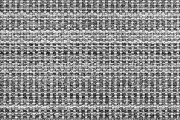 Tessuto bianco e nero lavorato a maglia texture di sfondo. tessuto grigio con un modello. Frammento tappeto di lana grigio, luminoso tappeto di vimini scuro - Foto, immagini