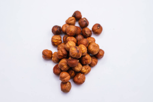 Whole hazelnut kernels lie on a white background. The autumn harvest. - Foto, Imagem