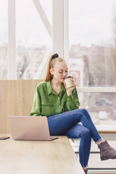 Junge schöne Frau sitzt mit einem Laptop, weichen Fokus Hintergrund - Foto, Bild
