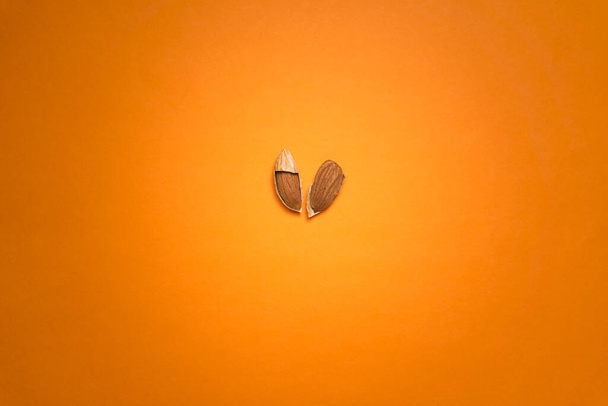 almond nut on an orange brown background - Φωτογραφία, εικόνα