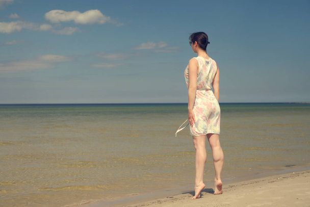 海のそばの夏のドレスの幸せな女の子 - 写真・画像
