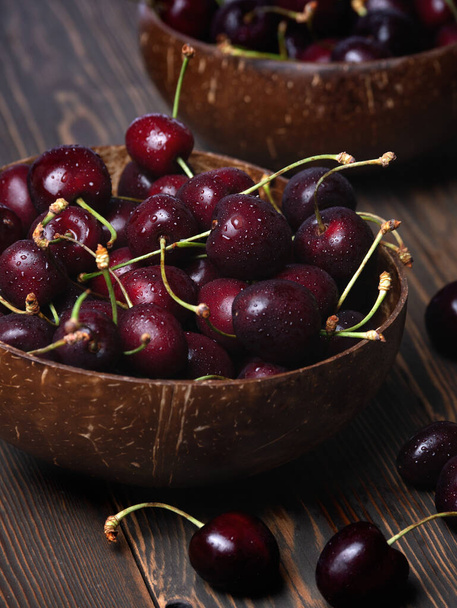 sweet cherry in coconut bowl on wooden desk - Photo, Image