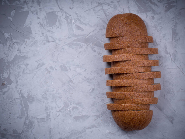 Свежий черный хлеб на деревянном столе. Домашнее хлебное тесто, деревенский хлеб в плетеной корзине. Свежеиспеченный традиционный хлеб на деревянном столе - Фото, изображение