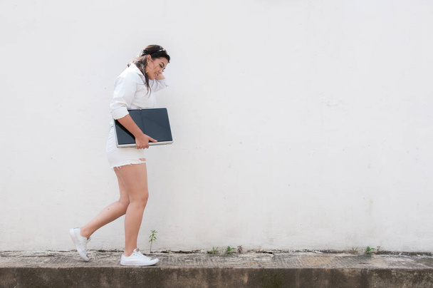 Latina žena kráčí po chodníku načítání svého počítače - Fotografie, Obrázek