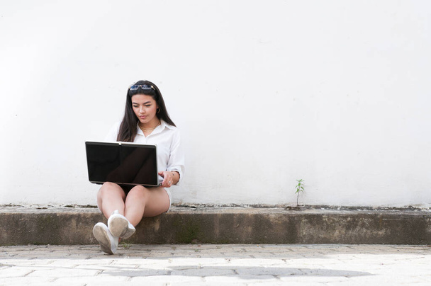 Latina Frau überprüft ihren Computer an einem sonnigen Tag - Foto, Bild