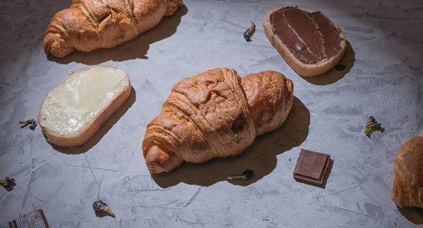 croissantit aamiaiseksi harmaalla pöydällä, panoraama konsepti. croissantit aamiaiseksi harmaalla pöydällä, panoraama konsepti - Valokuva, kuva