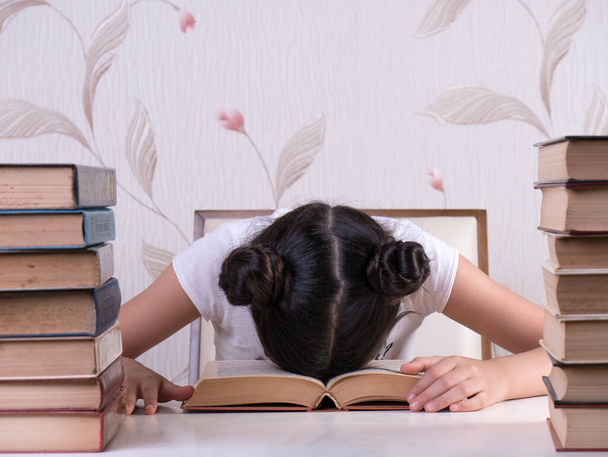 Schulmädchen lesen Buch, junges Mädchen gelangweilt und müde vom Lesen von Büchern zu Hause. gelangweilt fokussiert Brainy Girl Nerd Lesen Buch lernen Grammatik Vorbereitung Abschlussprüfung  - Foto, Bild