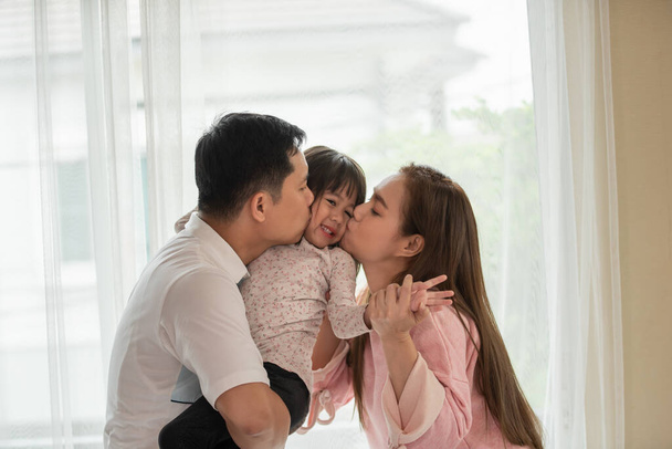 vader en moeder zoenen haar kind dochter, gelukkig aziatisch familie concept - Foto, afbeelding