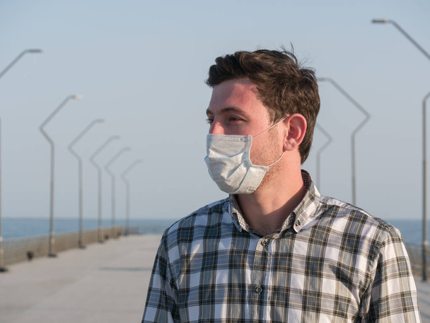 Mann mit Mundschutz während des Coronavirus-Ausbruchs. Viren verbreiten Grippeprävention. Mann mit Gesichtsmaske. Einmalmaske. Bleiben Sie sicher. aufhören covid 19. Sperrung - Foto, Bild