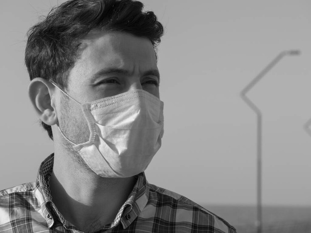 コロナウイルス発生時に顔マスクをした男。ウイルスはインフルエンザ予防のカランチンを広げる。フェイスマスクの男だ。使い捨てマスク。安全を確保しろ。コヴィッド19を止めて。ロックダウン - 写真・画像