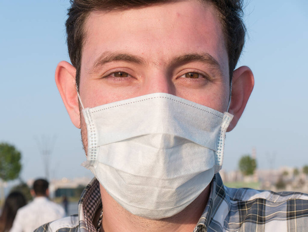 man wearing face mask during coronavirus outbreak. Virus spread flu prevention carantine. man in a facemask. disposable mask. stay safe . stop covid 19 . lockdown - Photo, Image