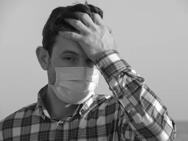 コロナウイルス発生時に顔マスクをした男。ウイルスはインフルエンザ予防のカランチンを広げる。フェイスマスクの男だ。使い捨てマスク。安全を確保しろ。コヴィッド19を止めて。ロックダウン - 写真・画像