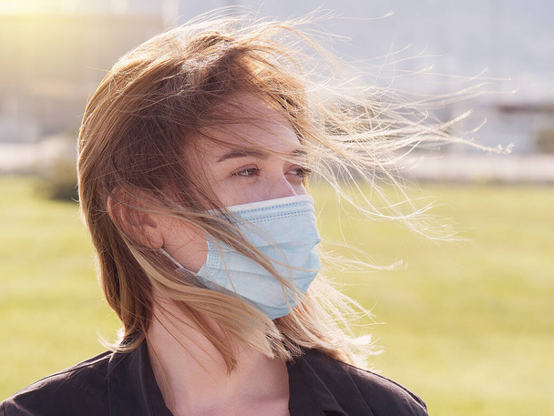 Frau mit Mundschutz während des Coronavirus-Ausbruchs. Viren verbreiten Grippeschutz-Quarantäne. Mädchen mit Gesichtsmaske. 19 Jahre alt. medizinische Maske - Foto, Bild