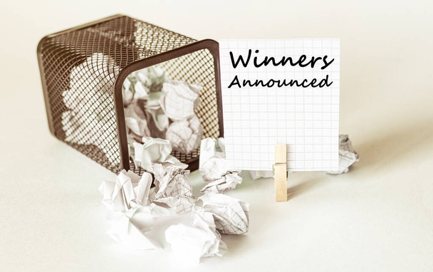 grumos blancos de papel caen fuera de la caja al papel en la inscripción Ganadores Anunciados - Foto, Imagen