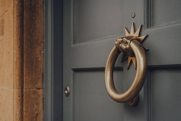 Feche-se de um batedor de porta de metal em uma porta da frente de madeira de uma casa. - Foto, Imagem