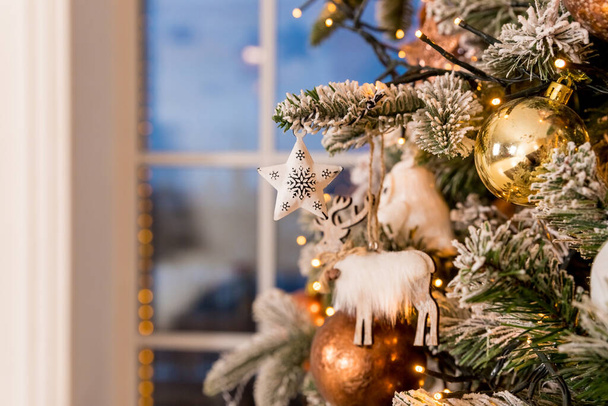 Kerstverlichting en kerstballen en decoraties detail.Gouden en bronzen kerst achtergrond - kerstballen, geschenkdozen, poinsettia takken, slingers - Foto, afbeelding
