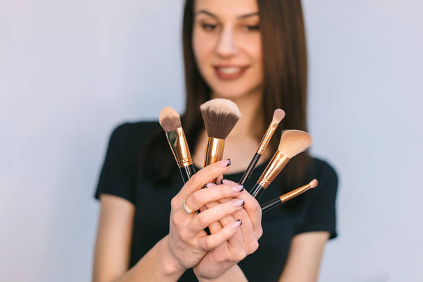 Professional visagiste makeup brushes. Cosmetology concept. Skin beauty care concept. Female fashion style. Girl has long hair. Makeup and cosmetics. - Fotografie, Obrázek