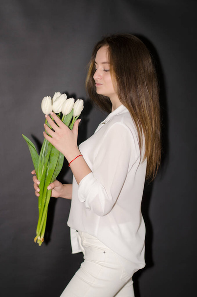 Portrait of girl in white together with tulips. - Foto, Bild
