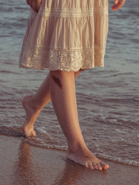 Woman wearing ethnic dress. Carefree boho girl in white summer dress walking on beach. Happy young woman relaxing on seashore. Summer vacation. Mindfulness and relaxation. Lifestyle - Fotoğraf, Görsel