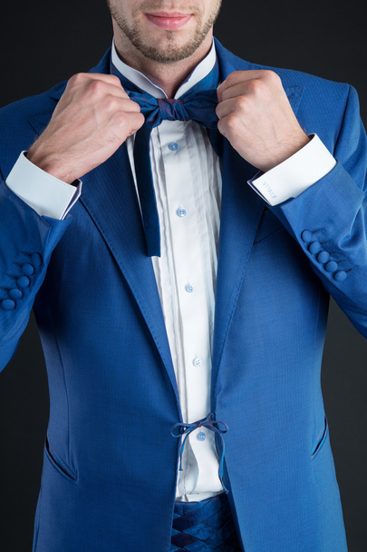青い蝶ネクタイと紺のスーツを着た男 - 写真・画像
